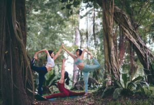 three women doing yoga at forest
